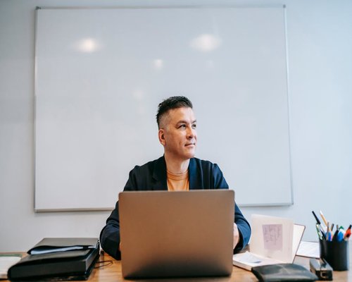 Person looking away from desk out the window